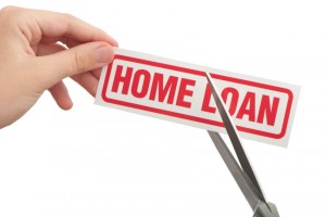 Scissors cutting through home loan sign